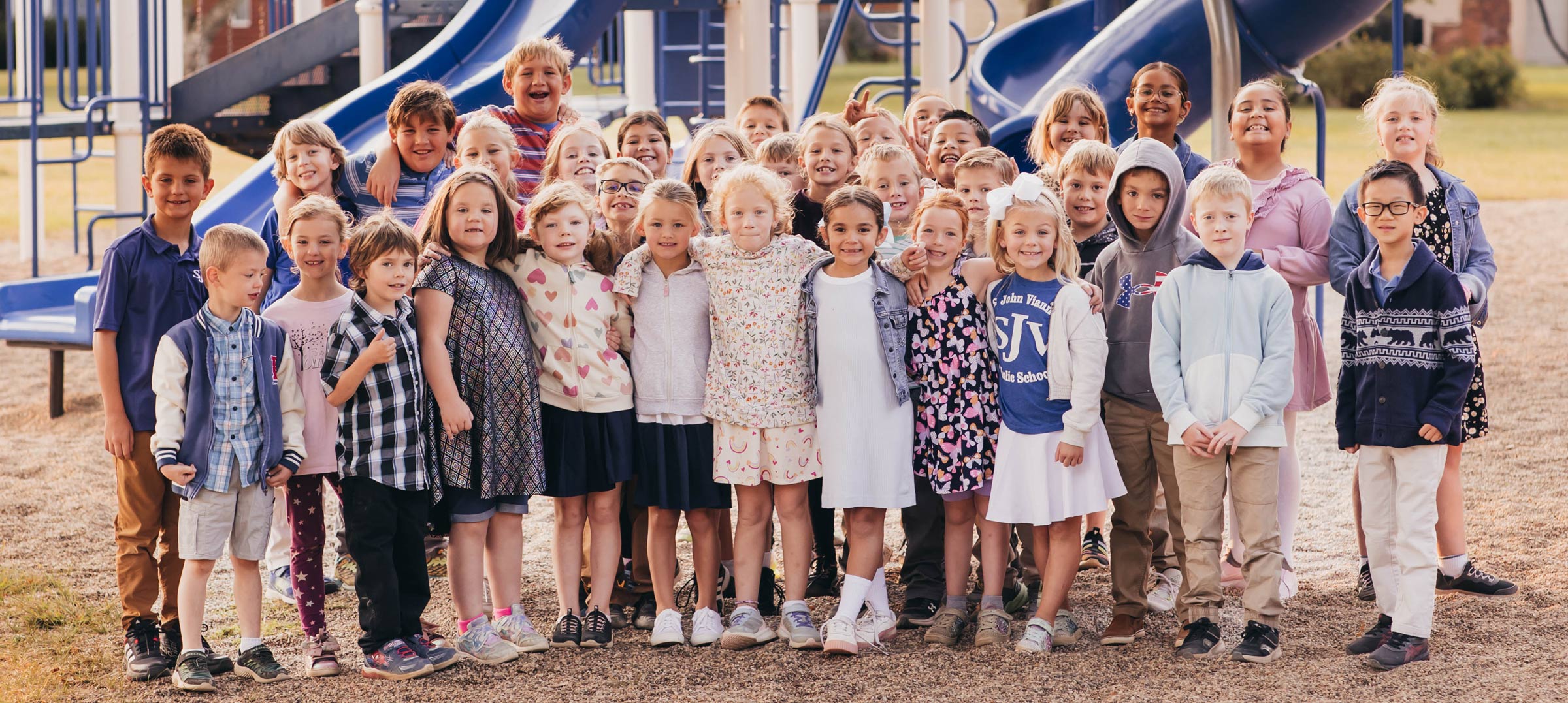 St. John Vianney Students standing in a group in the playground