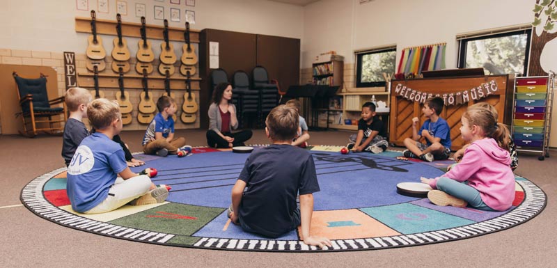 SJV 2nd grade students sitting in a circle at music class